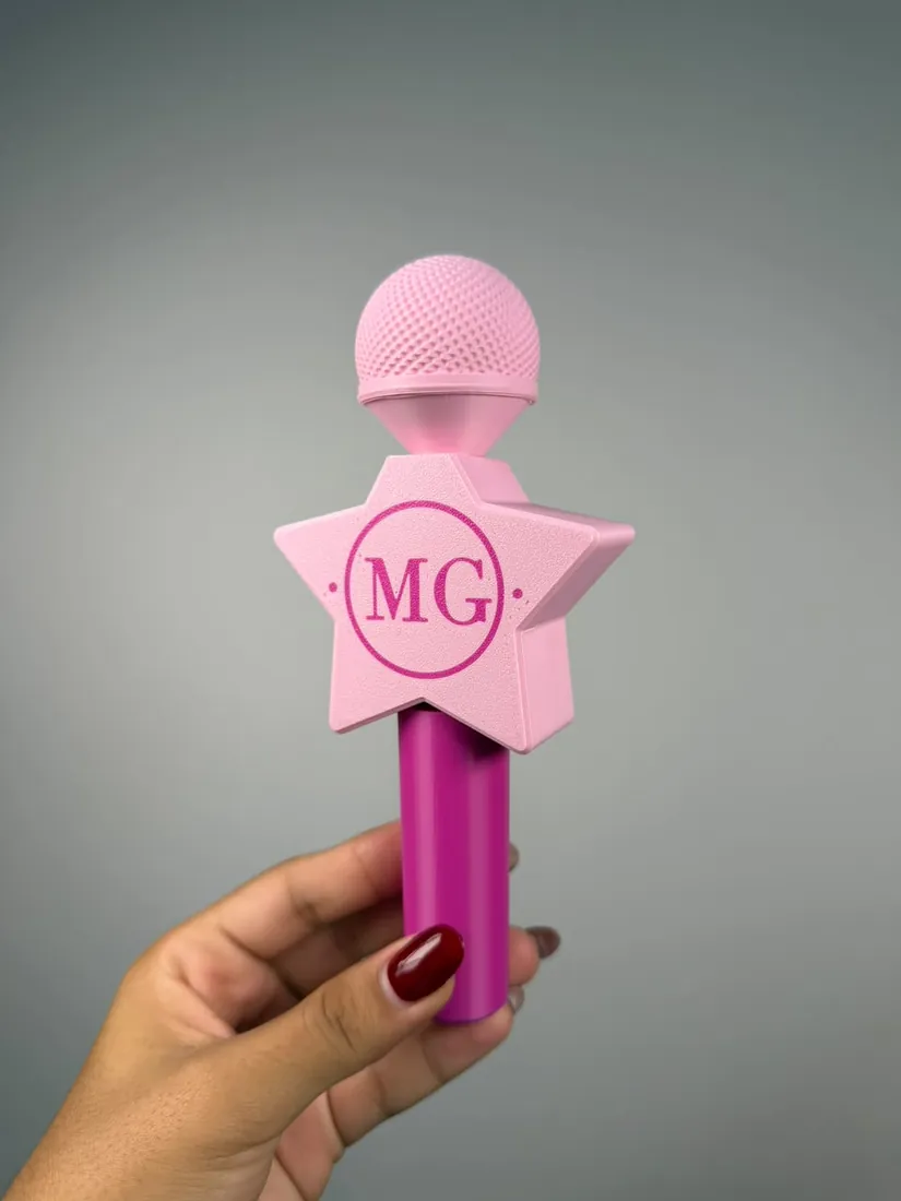 Micrófono impreso en 3D con iniciales en relieve, en la mano